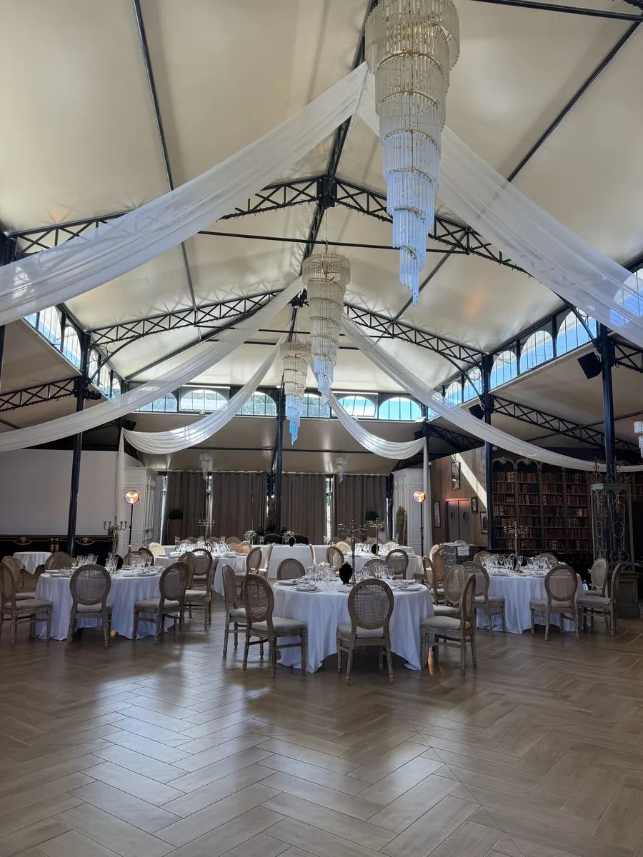 La salle de réception avec les tables rondes dressées