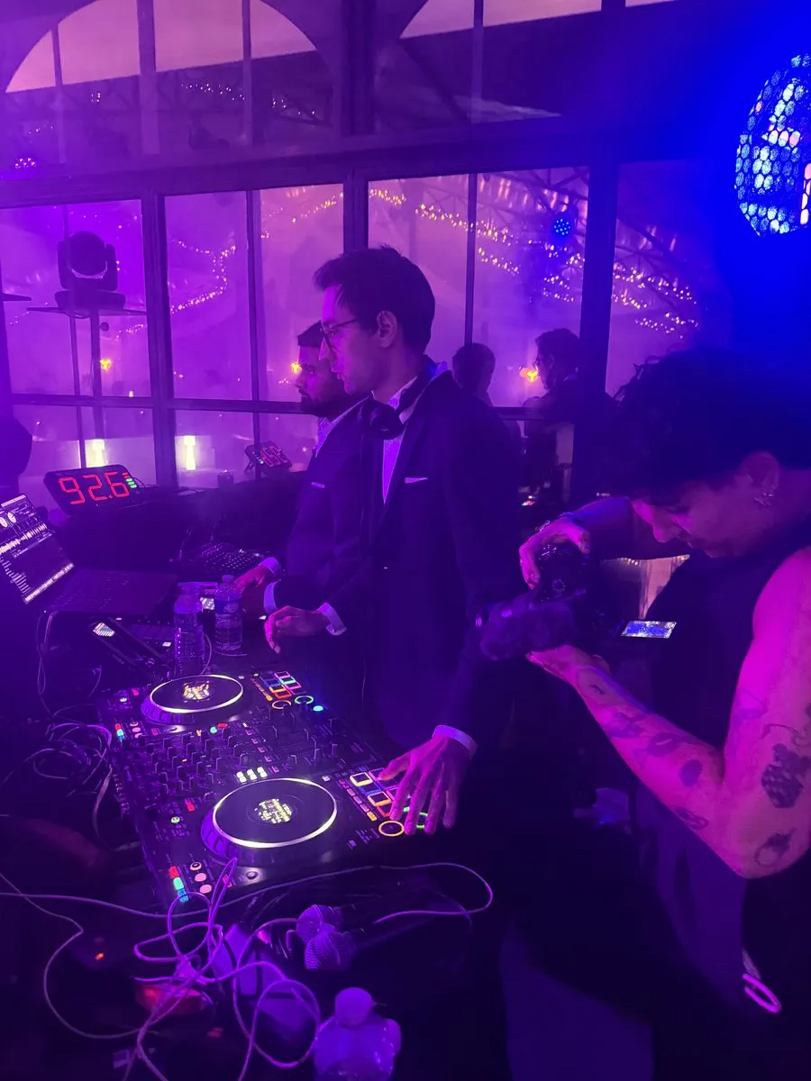 Le DJ aux platines pendant la soirée, filmé par un caméraman